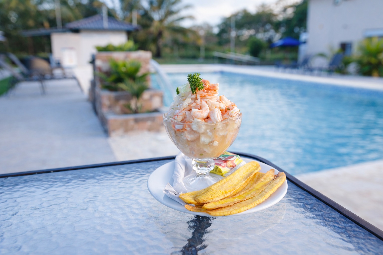 Cóctel de camarones con patacones junto a la piscina